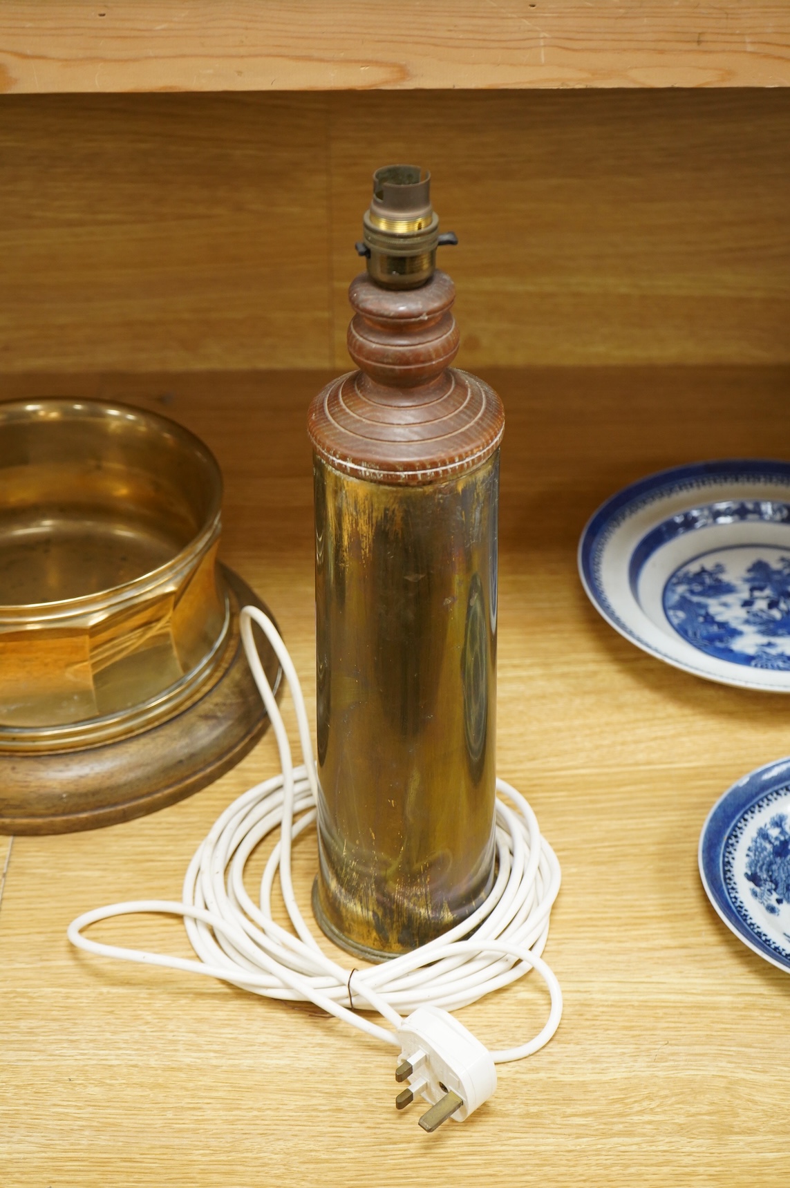 A bronze spitoon on plinth and a near pair of cartridge case table lamps, largest 46cm high